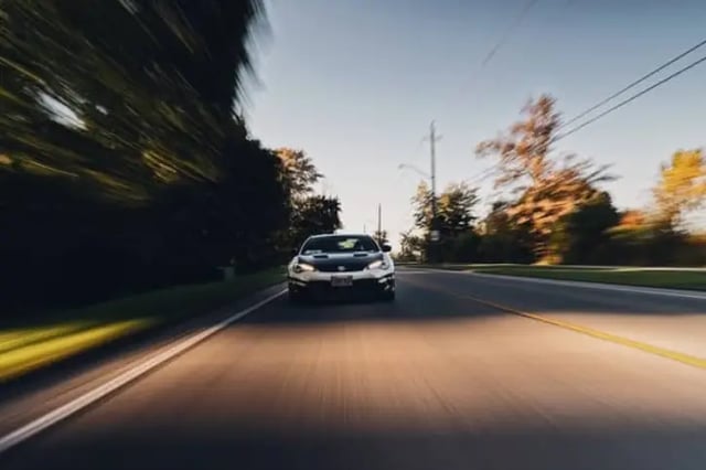 Car in motion driving down road