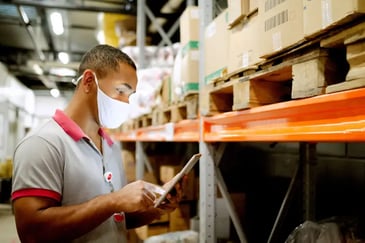 Employee with mask taking inventory in Retail store