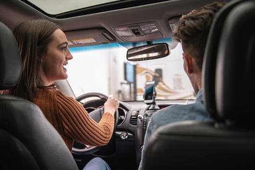 Woman driving vehicle with male passenger