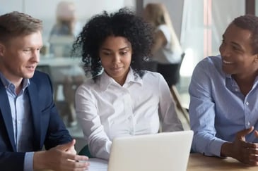 Male and female insurers collaborating with laptop