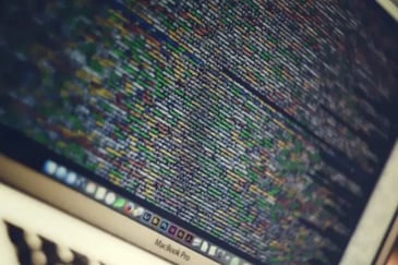 A close up of a MacBook screen showing code