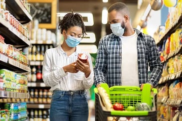 couple with masks shopping in a grocery shop aisle