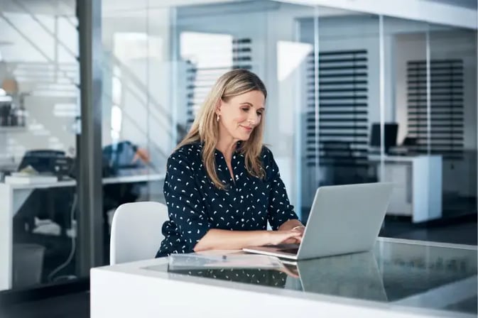 Female insurer using laptop in modern office