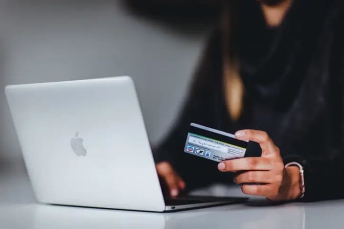 Female shopping online on laptop holding credit card