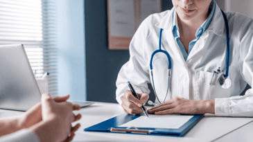 Female doctor writing prescription for a patient