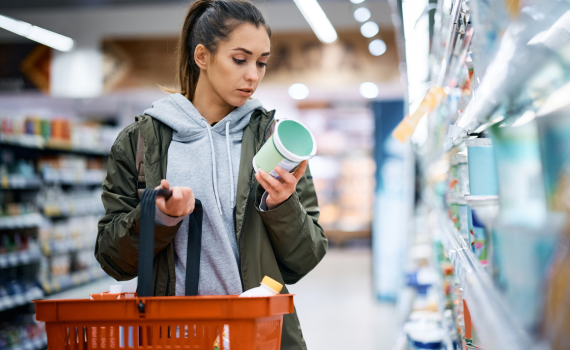 Female shopper checking label on grocery item