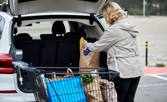 Senior woman loading groceries into car