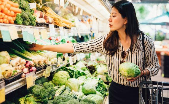 Female shopper grabbing vegetables from produce aisle