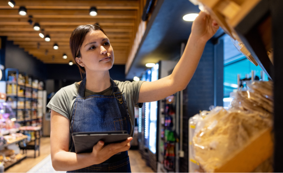 Female grocery employee checking inventory with tablet