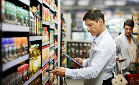 Male merchant checking prices with tablet