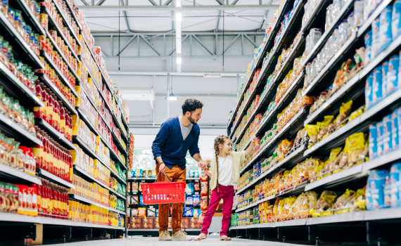 Father and daughter grabbing product off store shelf