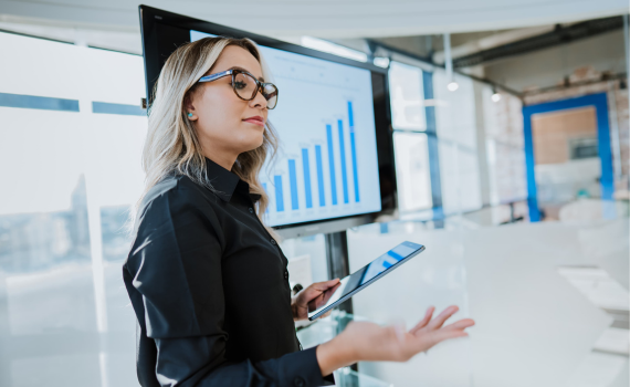 Female insurer presenting on company finances while holding tablet