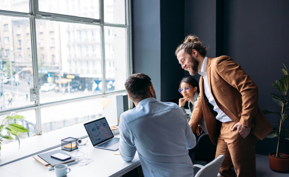 Male and female insurers collaborating in office using laptop