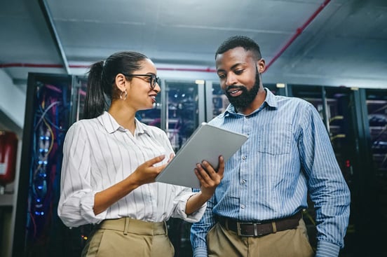 Female and male IT colleagues reviewing tablet