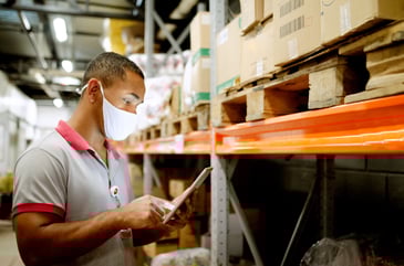 Employee with mask taking inventory in Retail store