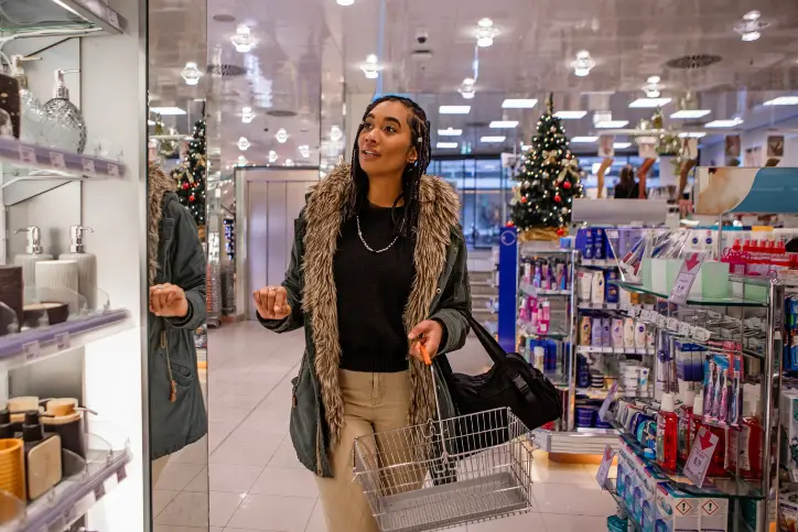 Woman shopping in drug store during holiday season with a Christmas tree in the background