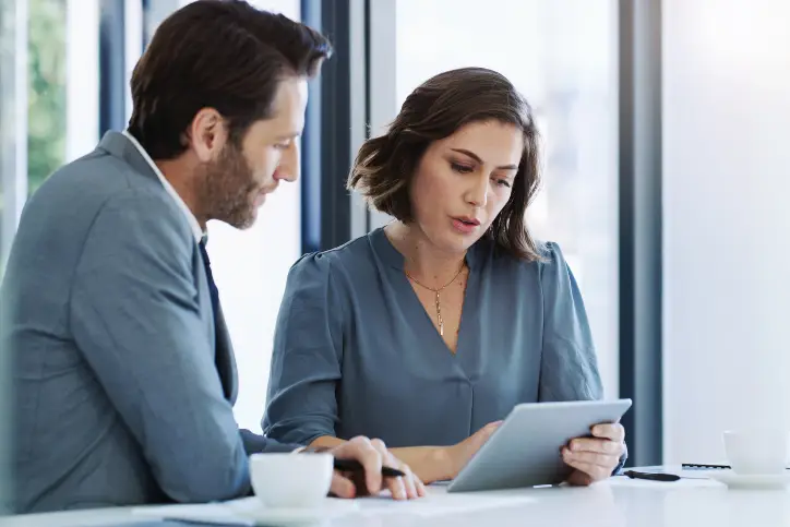 Female and male insurance colleagues collaborating on a tablet