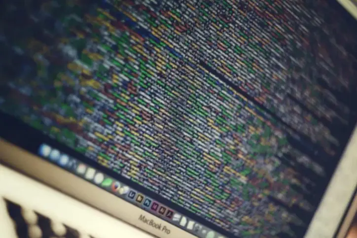 A close up of a MacBook screen showing code