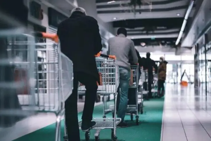 people with shopping carts lining up in grocery store