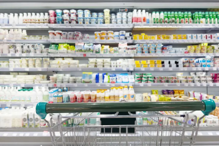 Grocery store dairy aisle with shopping cart